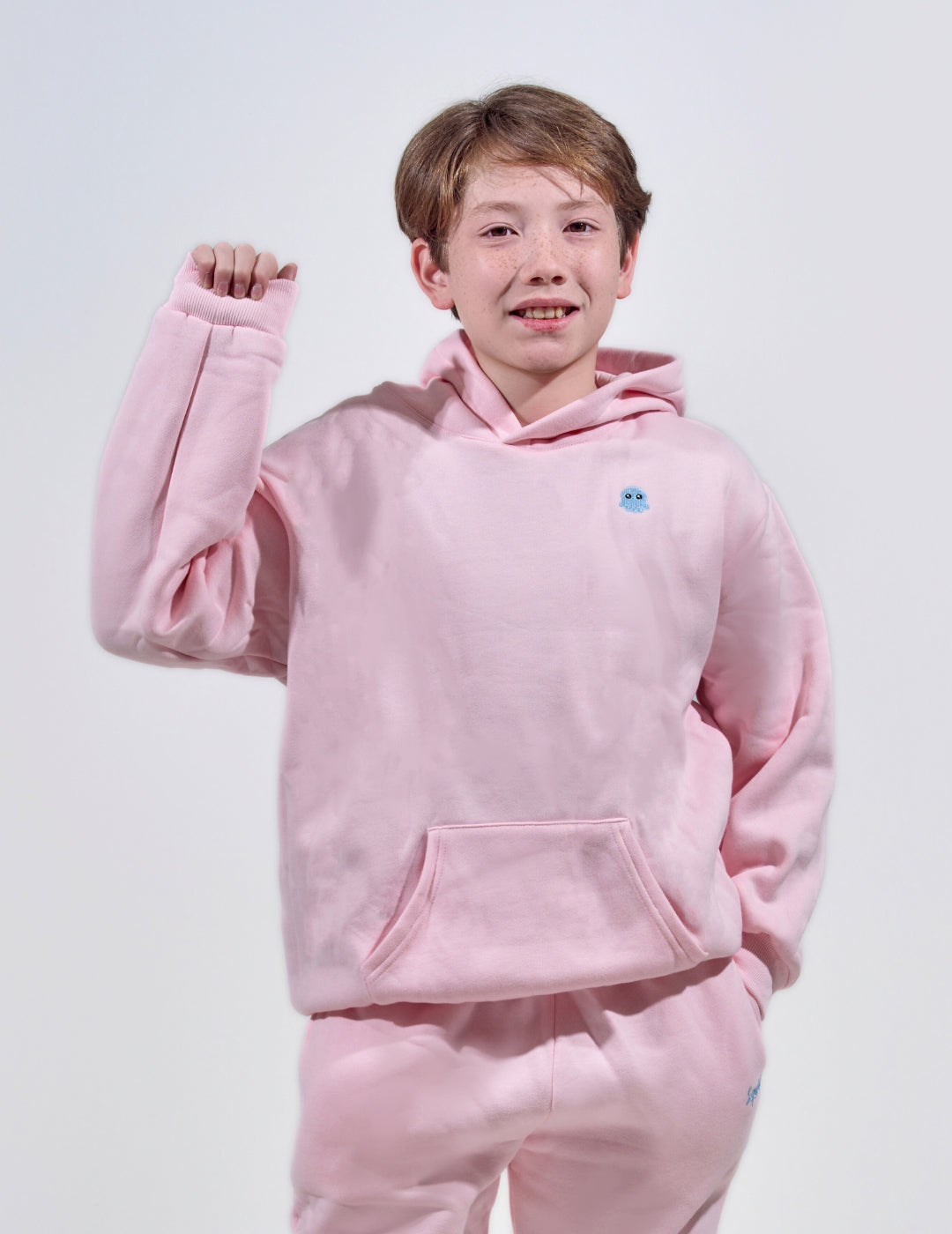 The Classic Kids Squiddy Hoodie in Baby Pink with boy model- Weighted Kids Hoodie with built-in squishies in the cuffs