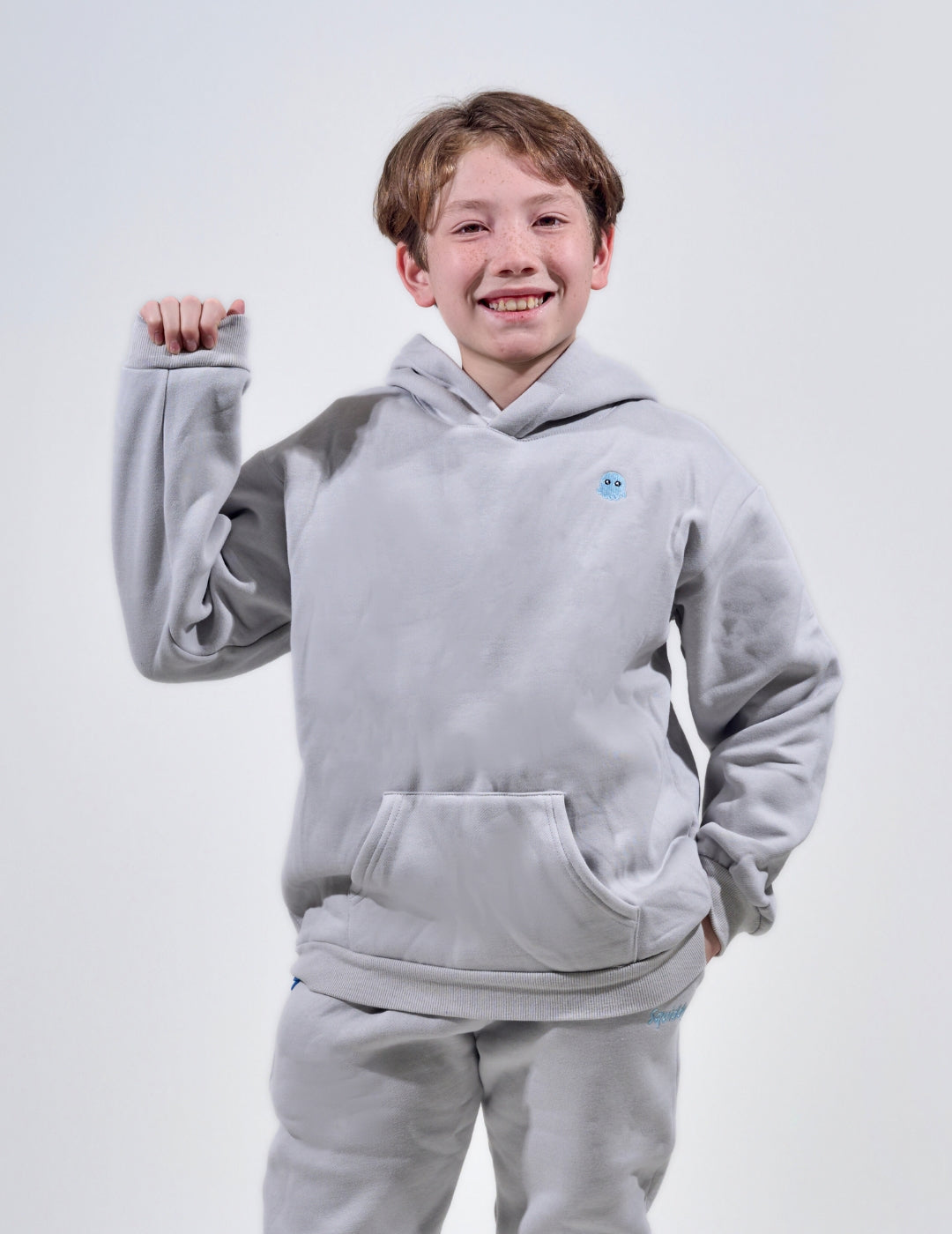 The Classic Kids Squiddy Hoodie in Fog Grey with boy model- Weighted Kids Hoodie with built-in squishies in the cuffs
