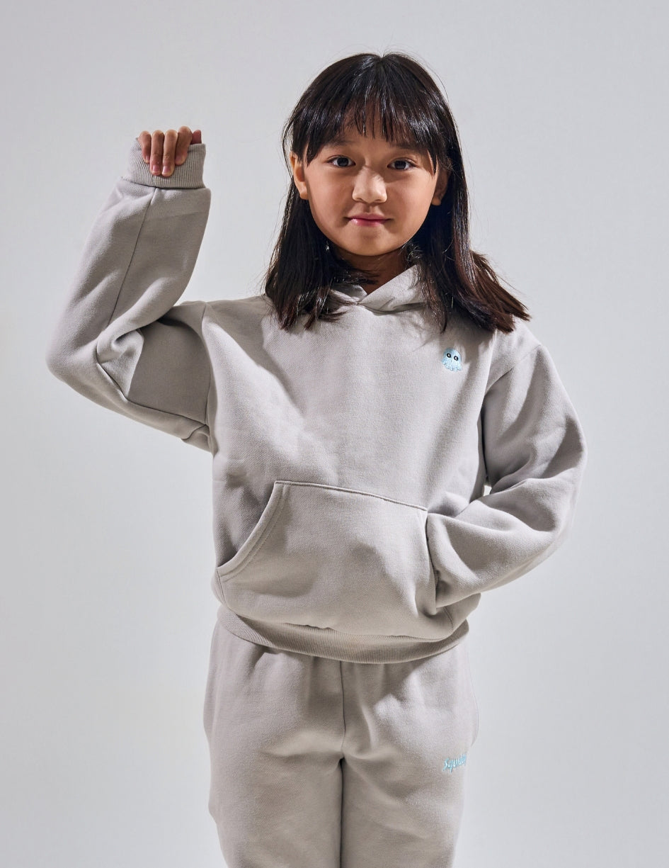 The Classic Kids Squiddy Hoodie in Fog Grey with girl model- Weighted Kids Hoodie with built-in squishies in the cuffs
