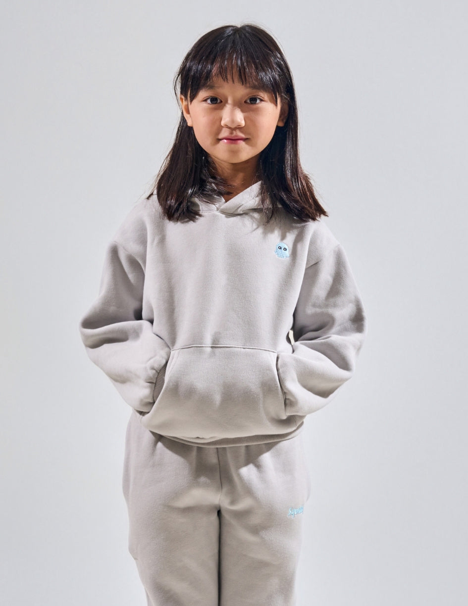 The Classic Kids Squiddy Hoodie in Fog Grey with girl model- Weighted Kids Hoodie with built-in squishies in the cuffs