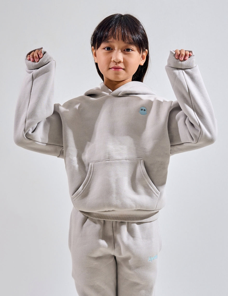 The Classic Kids Squiddy Hoodie in Fog Grey with girl model- Weighted Kids Hoodie with built-in squishies in the cuffs