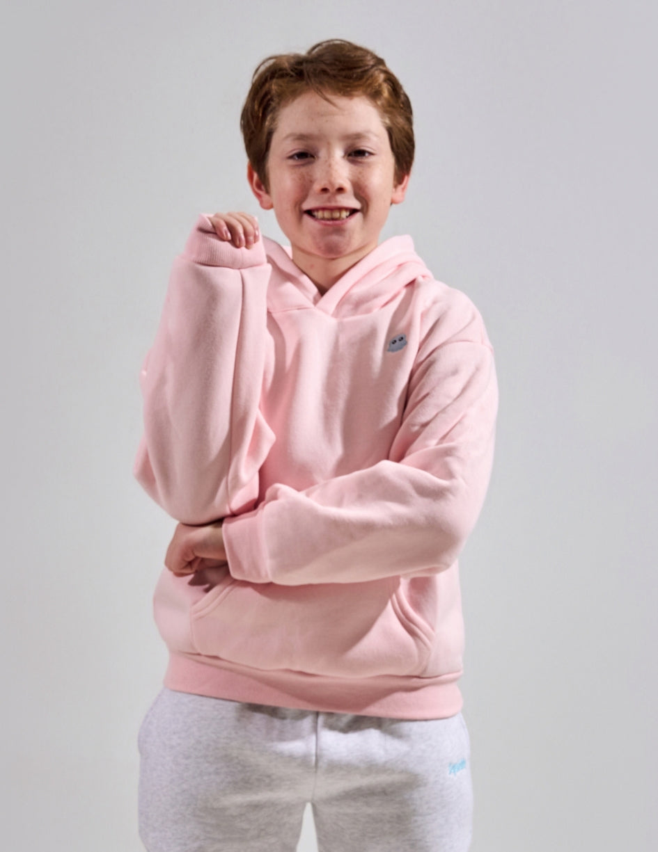 The Classic Kids Squiddy Hoodie in Baby Pink with boy model- Weighted Kids Hoodie with built-in squishies in the cuffs