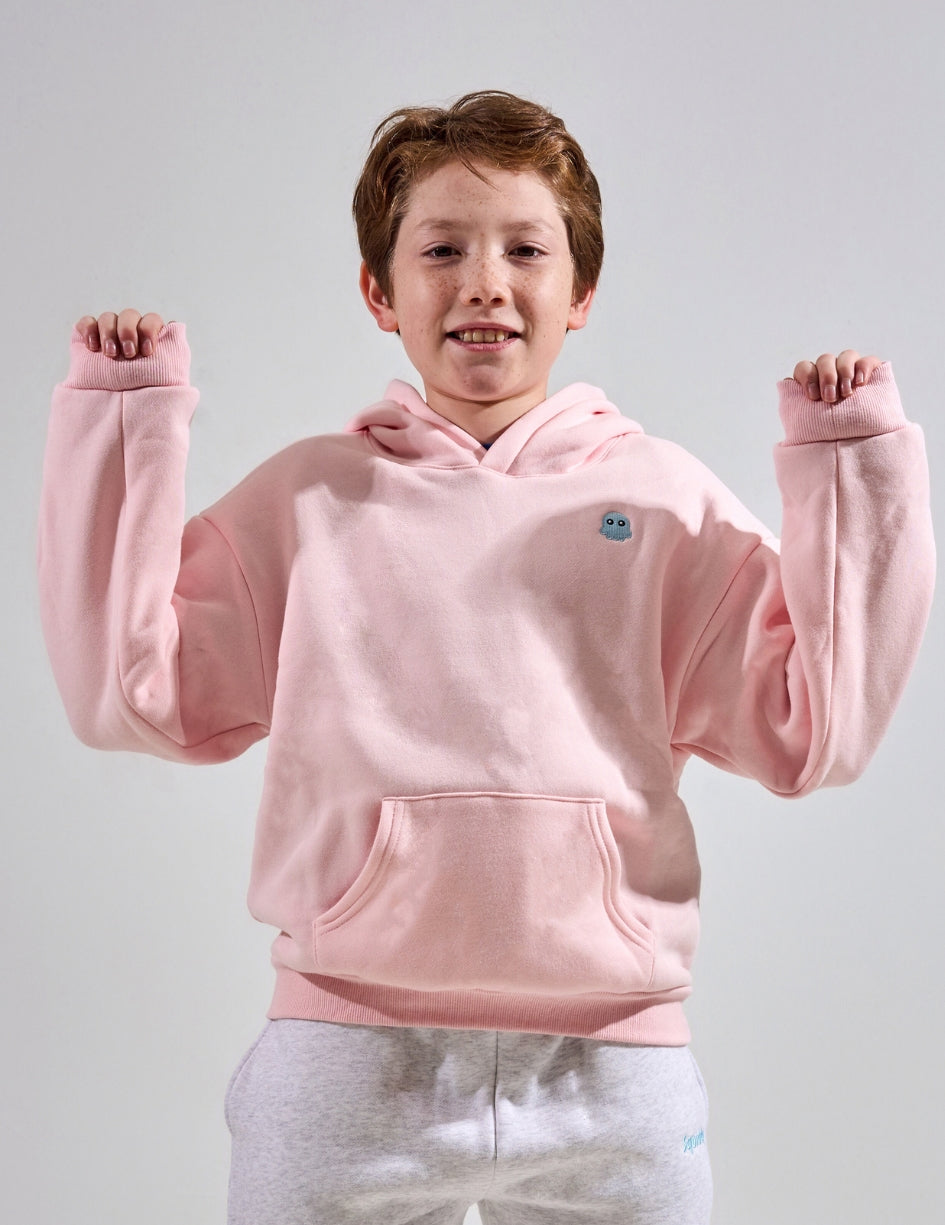 The Classic Kids Squiddy Hoodie in Baby Pink with boy model- Weighted Kids Hoodie with built-in squishies in the cuffs
