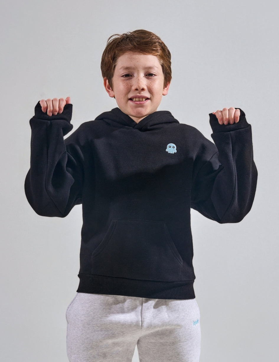 The Classic Kids Squiddy Hoodie in Black with boy model- Weighted Kids Hoodie with built-in squishies in the cuffs