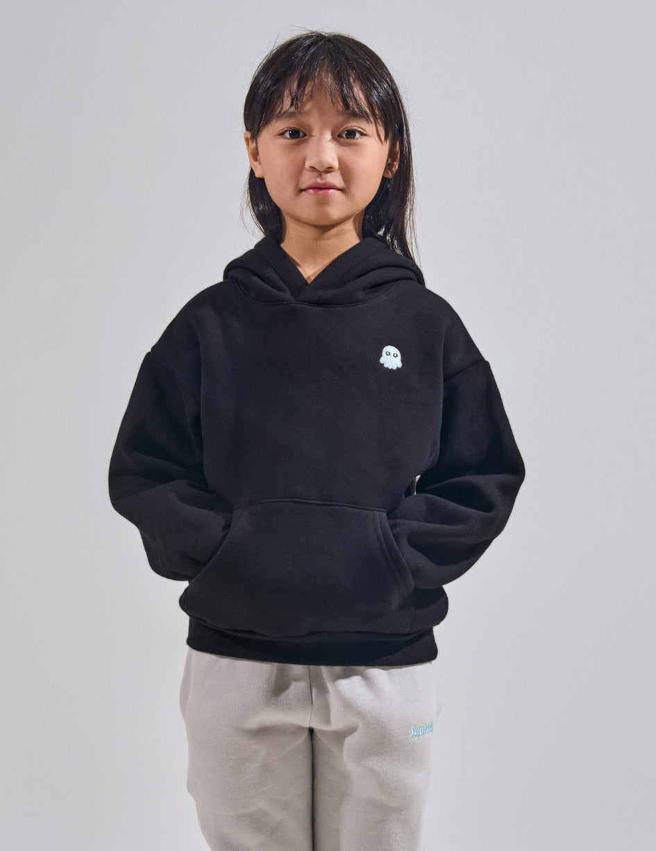 The Classic Kids Squiddy Hoodie in Black with girl model- Weighted Kids Hoodie with built-in squishies in the cuffs