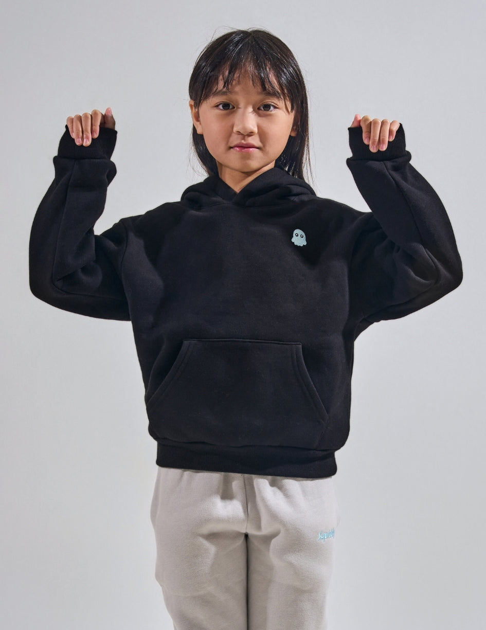 The Classic Kids Squiddy Hoodie in Black with girl model- Weighted Kids Hoodie with built-in squishies in the cuffs