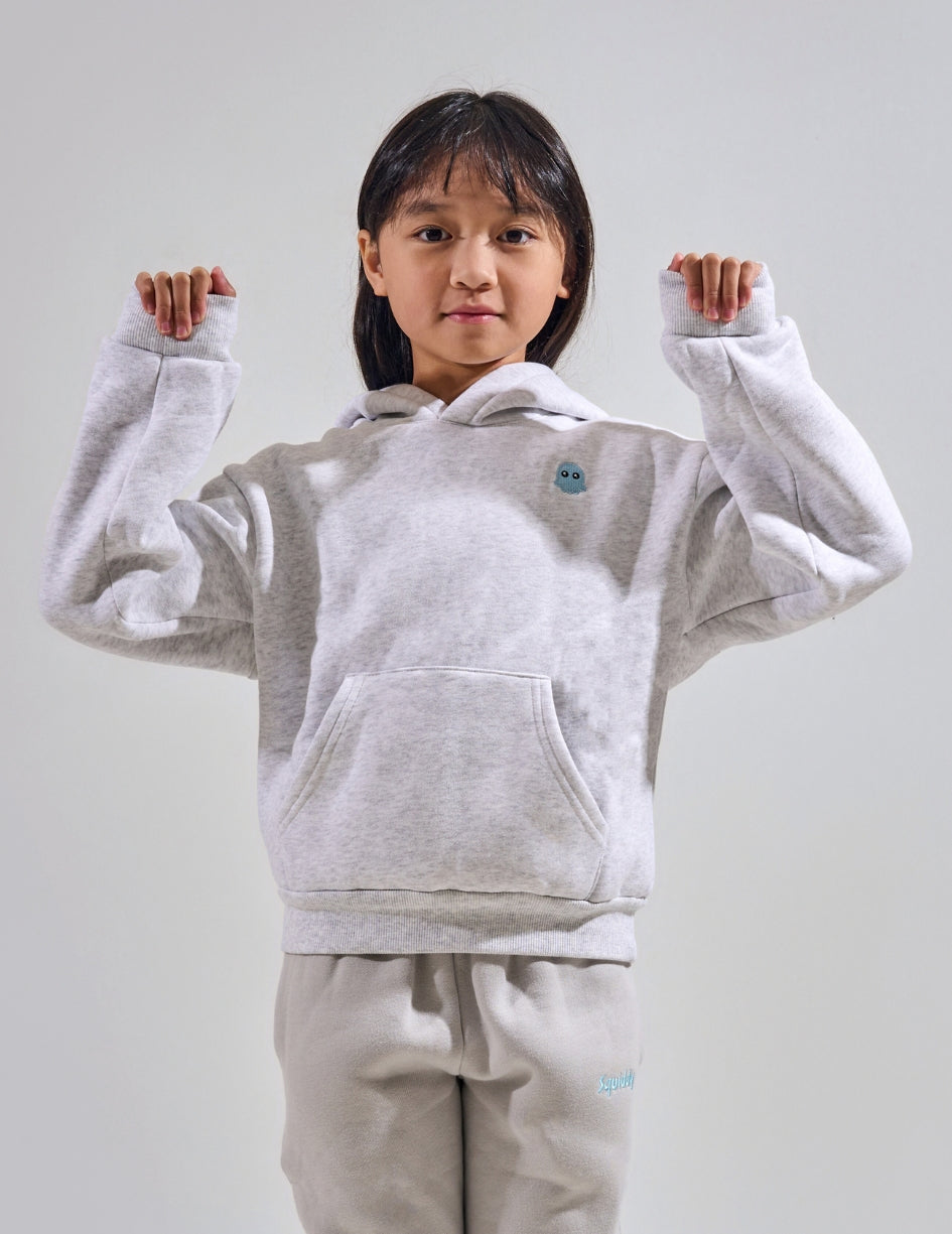The Classic Kids Squiddy Hoodie in Light Grey with girl model- Weighted Kids Hoodie with built-in squishies in the cuffs