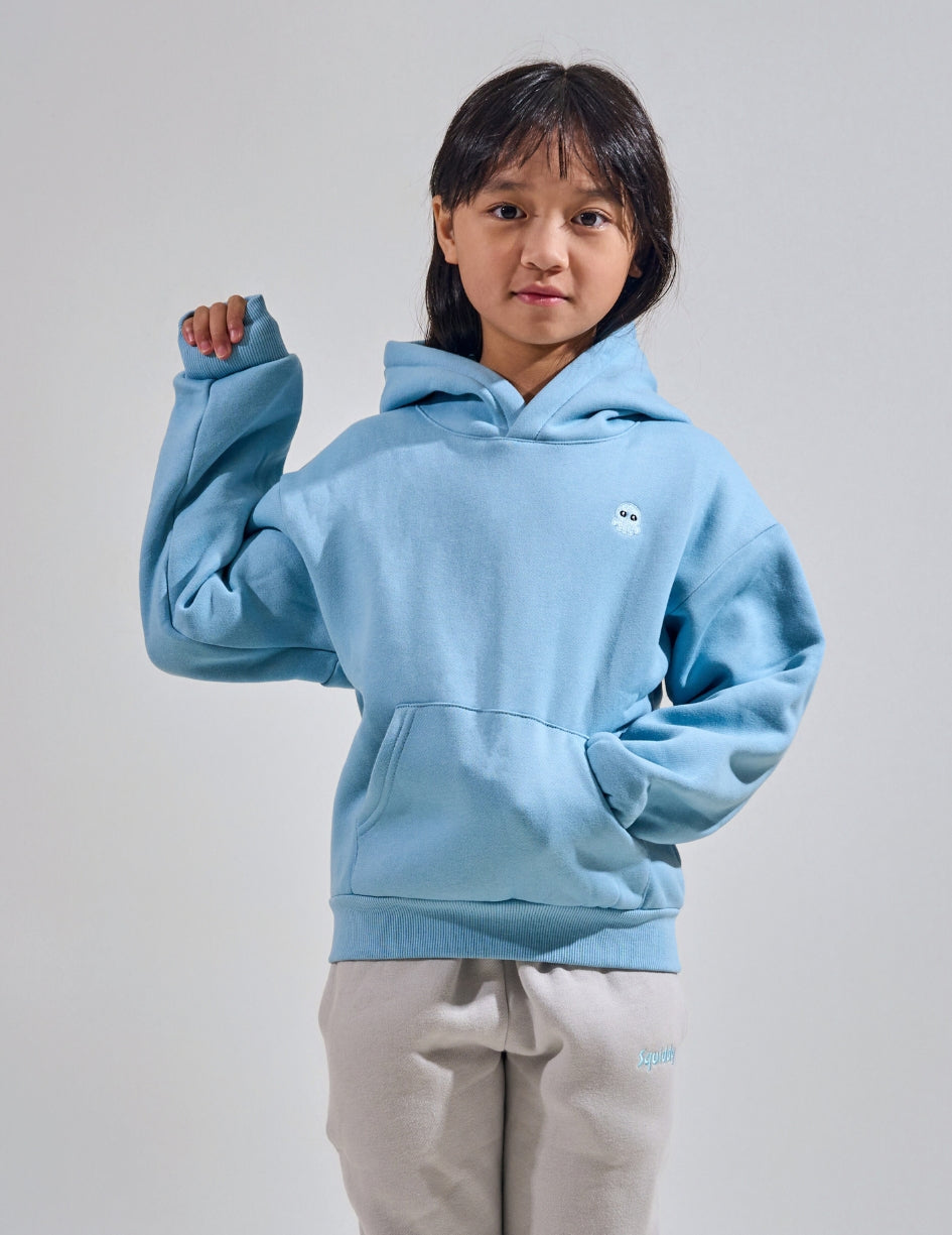 The Classic Kids Squiddy Hoodie in Sky Blue with girl model- Weighted Kids Hoodie with built-in squishies in the cuffs