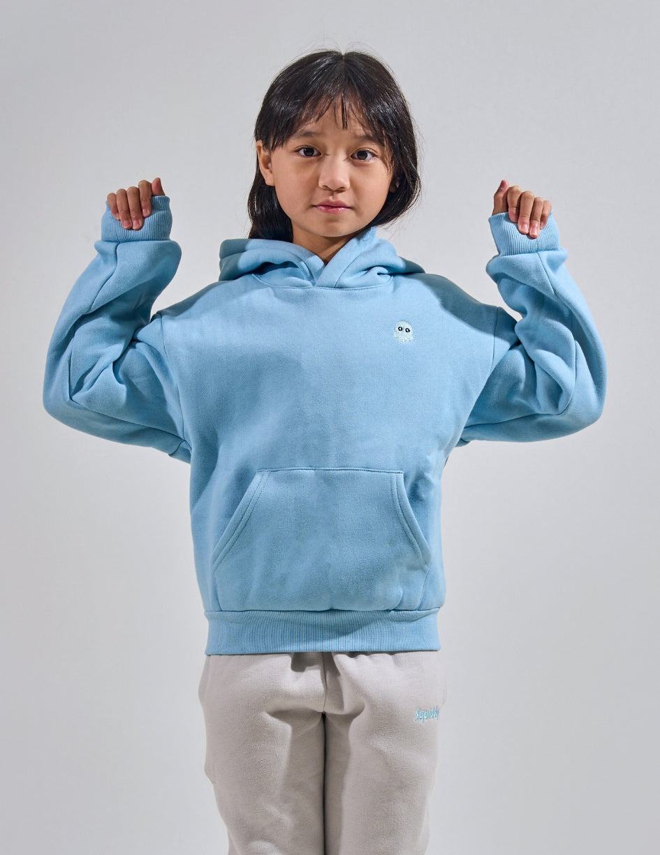 The Classic Kids Squiddy Hoodie in Sky Blue with girl model- Weighted Kids Hoodie with built-in squishies in the cuffs