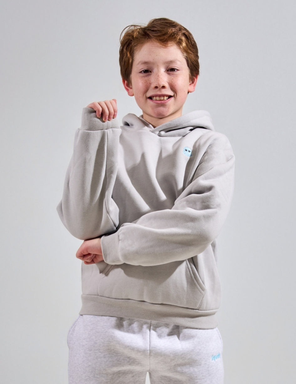 The Classic Kids Squiddy Hoodie in Fog Grey with boy model- Weighted Kids Hoodie with built-in squishies in the cuffs