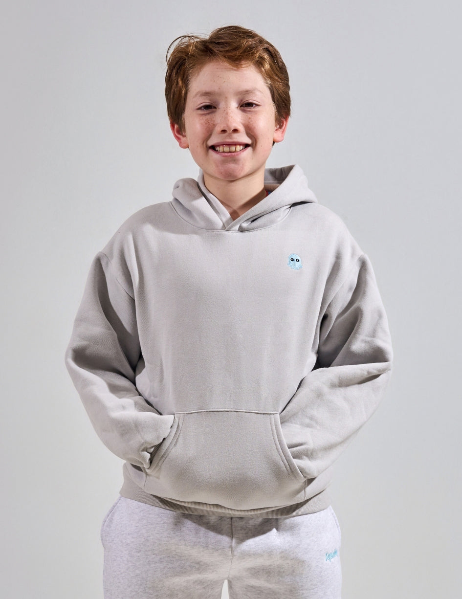 The Classic Kids Squiddy Hoodie in Fog Grey with boy model- Weighted Kids Hoodie with built-in squishies in the cuffs
