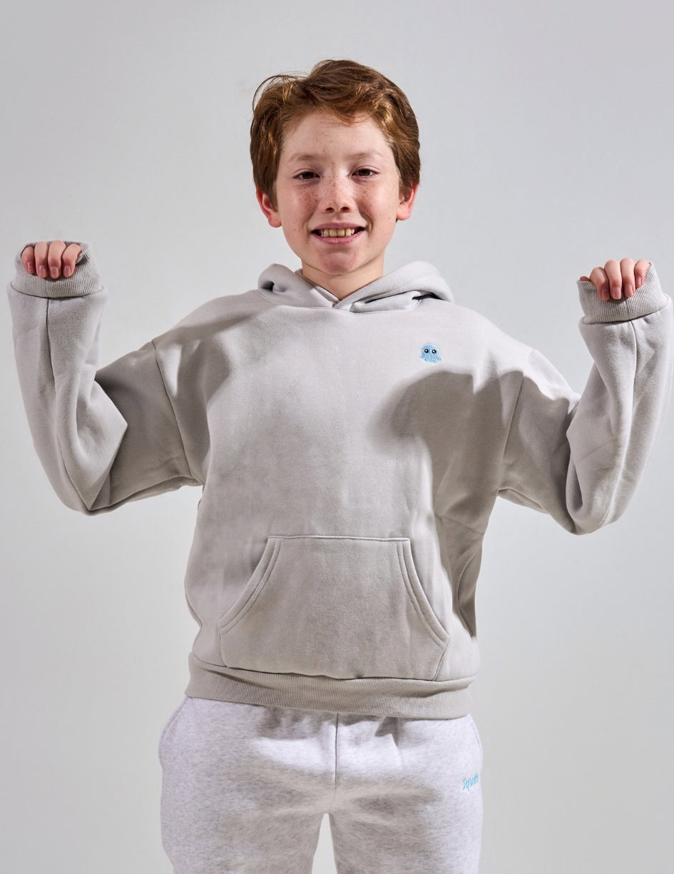 The Classic Kids Squiddy Hoodie in Fog Grey with boy model- Weighted Kids Hoodie with built-in squishies in the cuffs